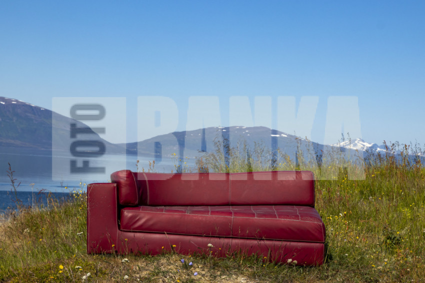Red sofa on the background of mountains
