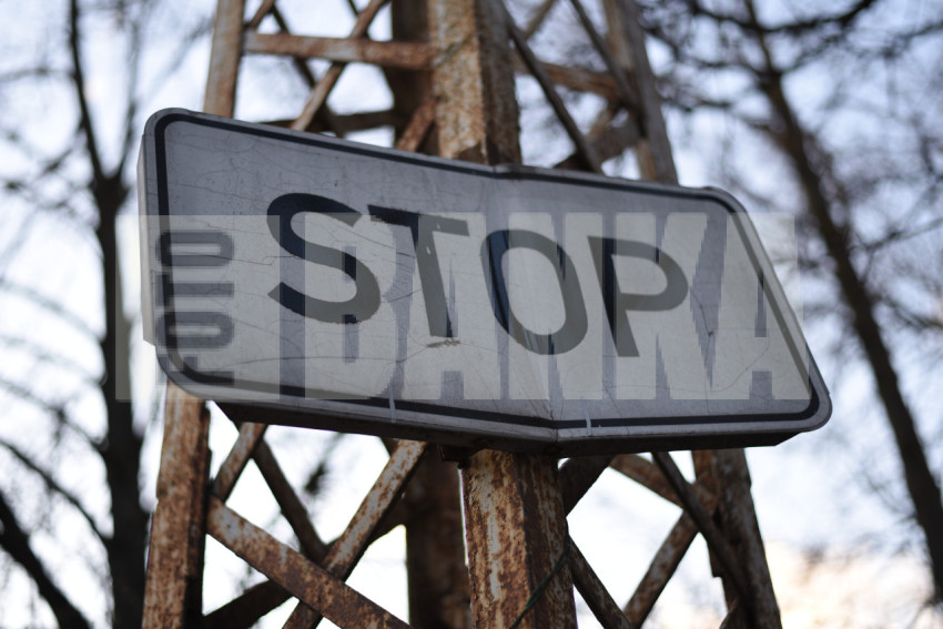 Zīme "Stop" uz rūsaina staba